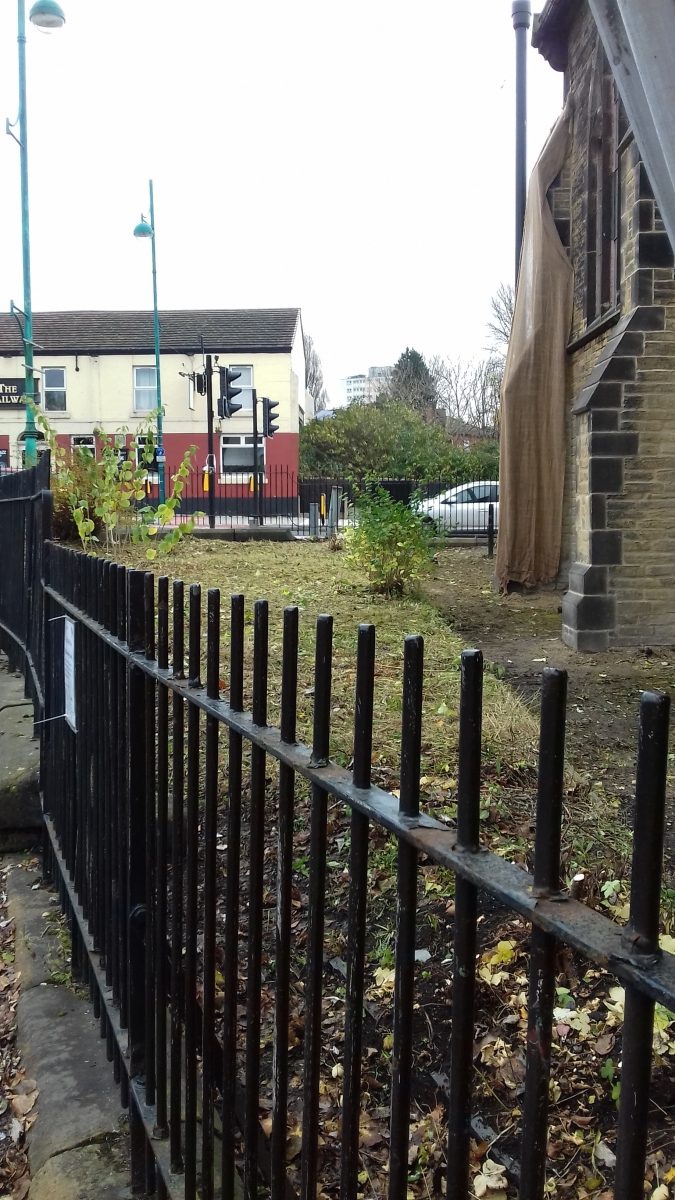 Railings in front of the cleared side of garden