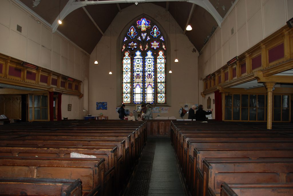 View inside showing the boxed in galleries and people talking at a coffee morning