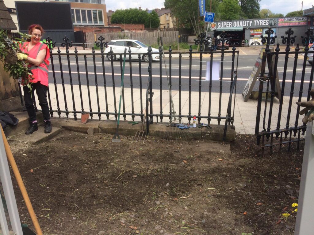 A large old gate hangs open onto newly cleared ground.