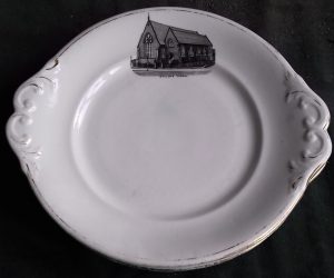 White cake plate with scrolled sides and etching of church top middle